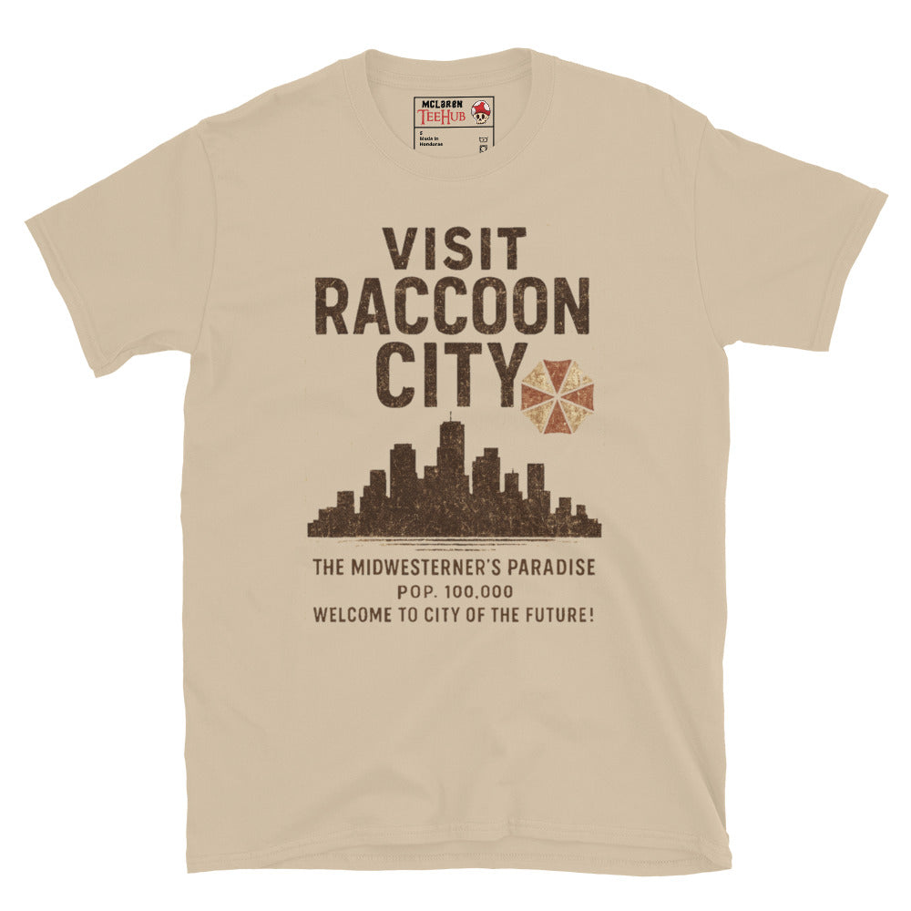 Sand T-shirt with vintage-style “Visit Raccoon City” graphic featuring city skyline, Umbrella Corp logo, and distressed text inspired by Resident Evil.