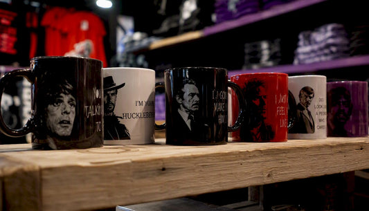 Close-up of ceramic movie quote mugs on shelf