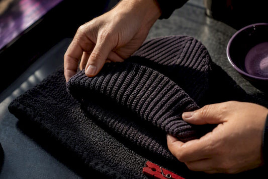 Hands reshaping a knit beanie while drying