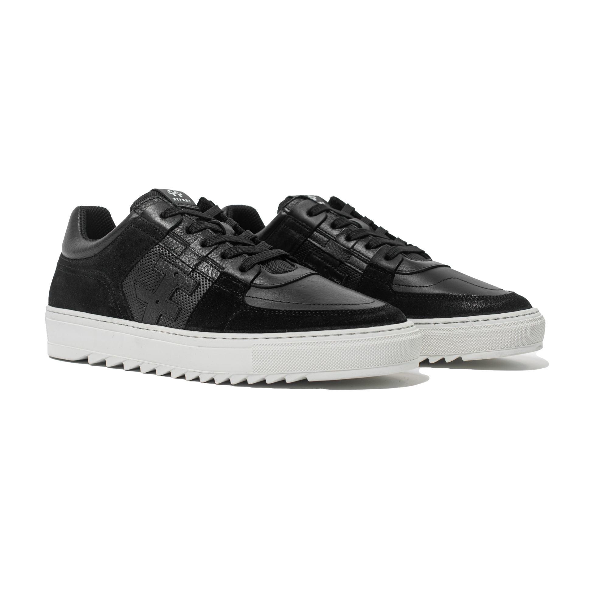 Pair of Black sneakers with white soles on a white background