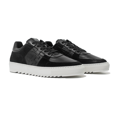Pair of Black sneakers with white soles on a white background