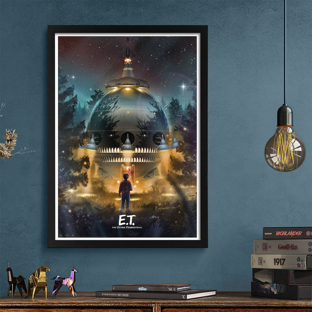 Framed 'E.T.' movie poster on a blue wall with a wooden shelf below.