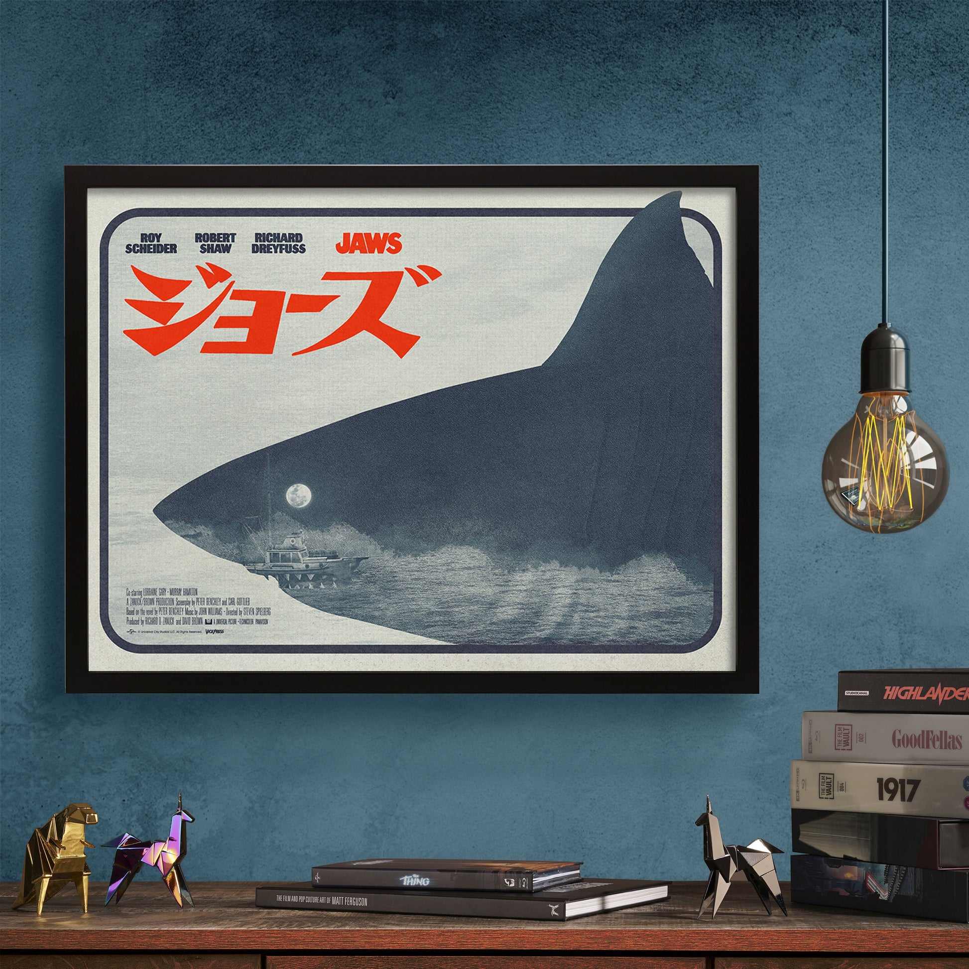 Framed 'Jaws' movie poster with a shark silhouette on a blue wall.