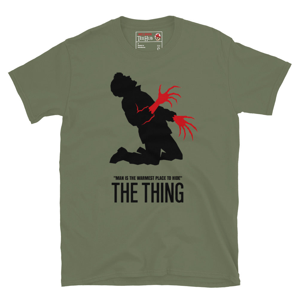 The Thing Bennings transformation t-shirt featuring minimalist horror artwork and the quote Man Is The Warmest Place To Hide. Military Green 