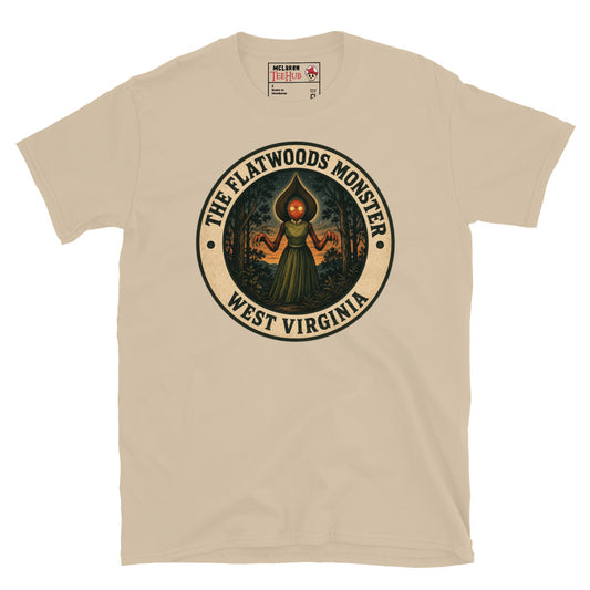 Sand Flatwoods Monster West Virginia t-shirt with vintage illustration badge featuring spade headed figure with glowing red eyes in green dress against forest sunset backdrop.