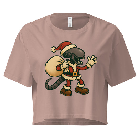 Cartoon Xenomorph in Santa suit holding gift sack – funny Alien Christmas crop top. Hazy Pink Colour
