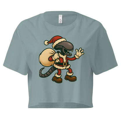 Cartoon Xenomorph in Santa suit holding gift sack – funny Alien Christmas crop top. Mineral colour